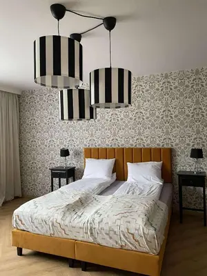 a bedroom with a bed with two lamps and two tables at Apartamenty TUTERRA I in Zabagnie