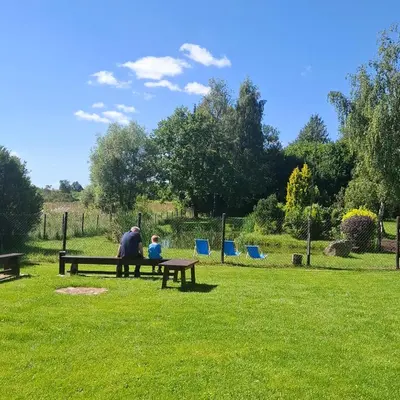 a man and a child sitting on a park bench at Apartamenty TUTERRA I in Zabagnie