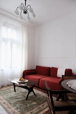 a living room with a red couch and a table at Vintage Soul Kazimierz Old Town in Kraków