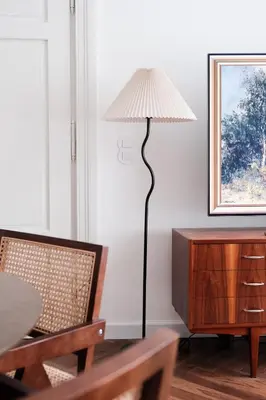 a floor lamp sitting next to a table with a chair at Vintage Soul Kazimierz Old Town in Kraków