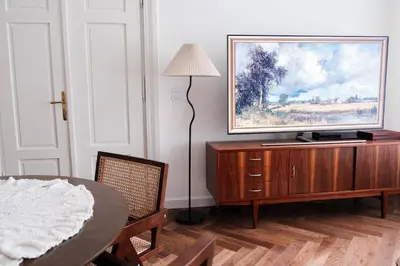 a living room with a table and a television on a cabinet at Vintage Soul Kazimierz Old Town in Kraków