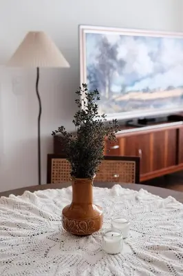 a vase with a plant in it sitting on a table at Vintage Soul Kazimierz Old Town in Kraków