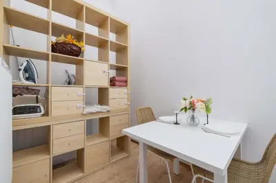 a dining room with a white table and shelves at Dietla Family Apartment in Kraków City Center by Noclegi Renters in Kraków