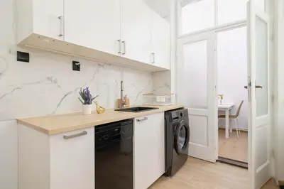 a white kitchen with a sink and a dishwasher at Dietla Family Apartment in Kraków City Center by Noclegi Renters in Kraków