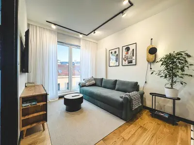 a living room with a couch and a large window at Bakelit Studio - Design hideaway - Calm, quality & location in Kraków