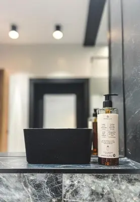 a bottle of soap on a shelf in front of a mirror at Bakelit Studio - Design hideaway - Calm, quality & location in Kraków