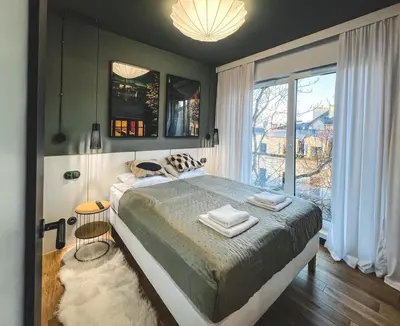 a bedroom with a large bed and a large window at Bakelit Studio - Design hideaway - Calm, quality & location in Kraków