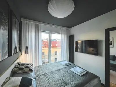 a bedroom with a bed and a large window at Bakelit Studio - Design hideaway - Calm, quality & location in Kraków