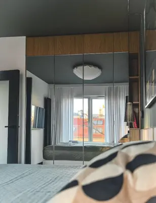 a bedroom with mirrored walls and a bed with a window at Bakelit Studio - Design hideaway - Calm, quality & location in Kraków