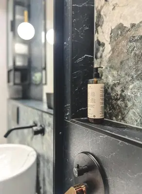 a bathroom with a bottle of perfume on a counter at Bakelit Studio - Design hideaway - Calm, quality & location in Kraków