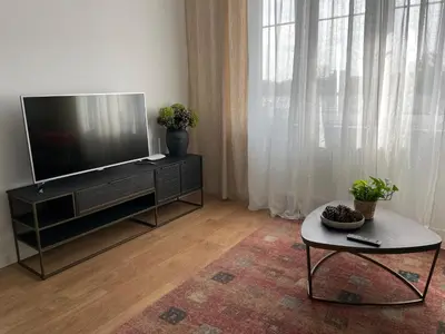 a living room with a flat screen tv and a table at Apartament Oboźna in Kraków
