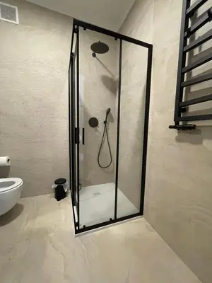 a shower with a glass door in a bathroom at Apartament Oboźna in Kraków