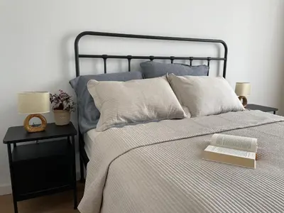 a bedroom with a bed with a book on it at Apartament Oboźna in Kraków