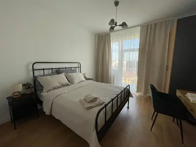 a bedroom with a bed and a desk and a window at Apartament Oboźna in Kraków