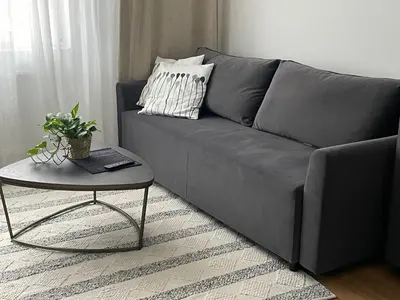 a gray couch with a table in a living room at Apartament Oboźna in Kraków