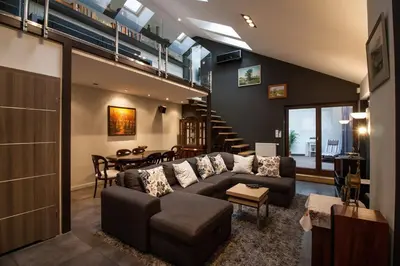 a living room with a couch and a dining room at Large Krakow Apartment - Near Kazimierz - City Center in Kraków