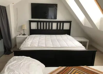 a bedroom with a bed with a tv on the wall at Large Krakow Apartment - Near Kazimierz - City Center in Kraków
