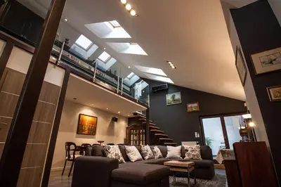 a living room with a couch and a staircase at Large Krakow Apartment - Near Kazimierz - City Center in Kraków