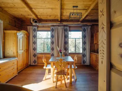 a dining room in a log cabin with a table and chairs at Apartamenty Przystań 18 Gorce w Rabce Zdrój in Rabka