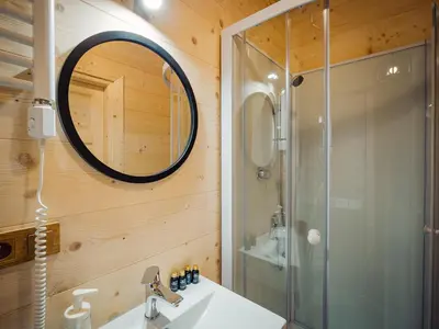 a bathroom with a shower and a sink and a mirror at Apartamenty Przystań 18 Gorce w Rabce Zdrój in Rabka