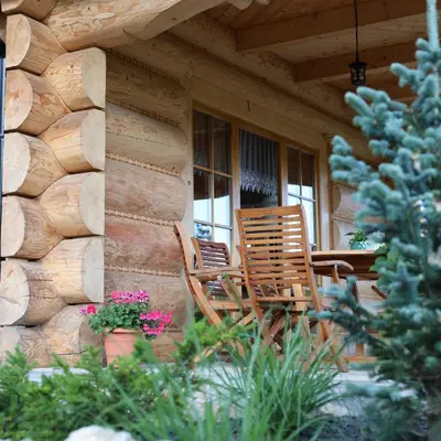 two chairs sitting on the porch of a cabin at Leśny Zakątek Zawoja in Stryszawa