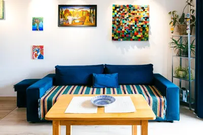 a blue couch in a living room with a table at Walerego Sławka Apartament in Kraków