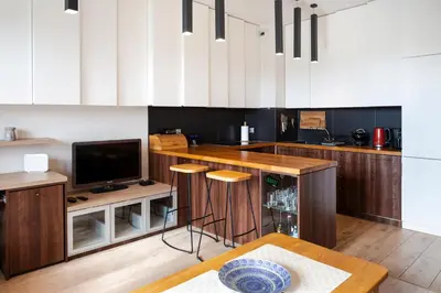 a kitchen with a bar with a tv and a table at Walerego Sławka Apartament in Kraków