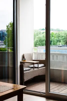 a balcony with a chair and a table and a window at Walerego Sławka Apartament in Kraków