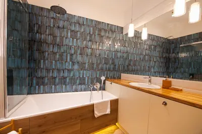 a bathroom with a bath tub and a sink at Walerego Sławka Apartament in Kraków