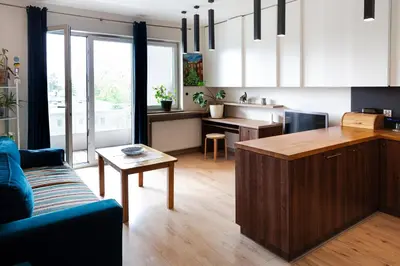 a kitchen and living room with a couch and a table at Walerego Sławka Apartament in Kraków