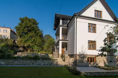 a large white house with a yard at Apartamenty Watra in Rabka