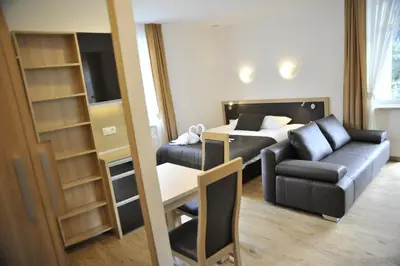 a hotel room with a bed and a couch and a table at Apartamenty Watra in Rabka