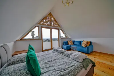 a bedroom with a bed and a large window at Góralski dom balia kominek Lawendowy Dom na Wichrowym Wzgórzu in Łętownia Dolna