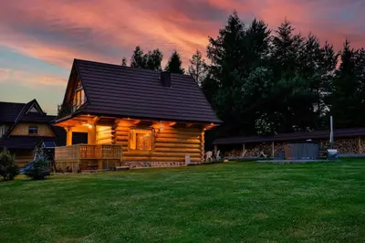 a log cabin with a sunset in the background at Góralski dom balia kominek Lawendowy Dom na Wichrowym Wzgórzu in Łętownia Dolna