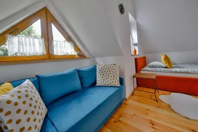 a living room with a blue couch and a window at Góralski dom balia kominek Lawendowy Dom na Wichrowym Wzgórzu in Łętownia Dolna