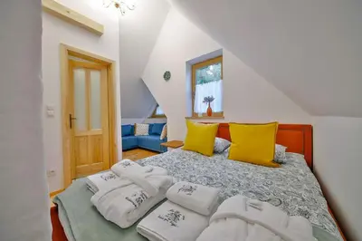 a bedroom with a bed with white and yellow pillows at Góralski dom balia kominek Lawendowy Dom na Wichrowym Wzgórzu in Łętownia Dolna