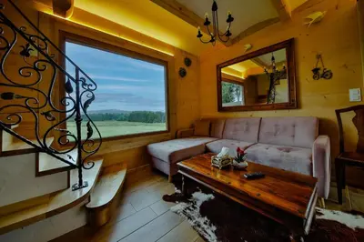 a living room with a couch and a large window at Góralski dom balia kominek Lawendowy Dom na Wichrowym Wzgórzu in Łętownia Dolna