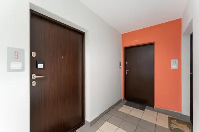 two doors in a hallway with orange and white walls at Osiedle Piastów Charming Apartment by BookingHost in Kraków