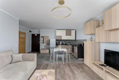 a living room with a couch and a table at Osiedle Piastów Charming Apartment by BookingHost in Kraków