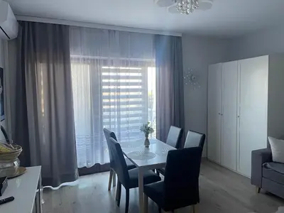 a dining room with a table and chairs and a window at Apart Wielicka 57 in Kraków