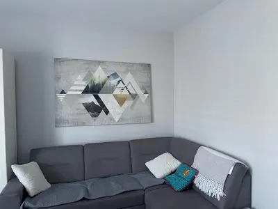 a living room with a couch and a painting on the wall at Apart Wielicka 57 in Kraków