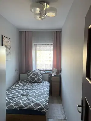 a bedroom with a bed and a desk and a window at Apart Wielicka 57 in Kraków