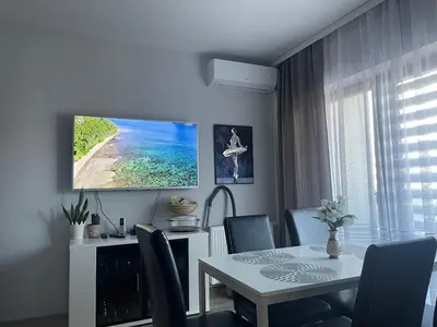 a dining room with a table and a tv on the wall at Apart Wielicka 57 in Kraków