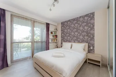a bedroom with a large white bed and a window at Łagiewniki Homely Apartment by BookingHost in Kraków