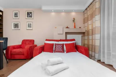 a bedroom with a red bed and a red chair at Łagiewniki Homely Apartment by BookingHost in Kraków