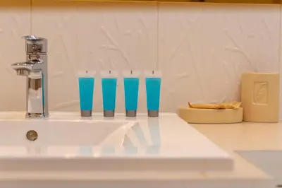 a row of blue glasses sitting on top of a sink at Łagiewniki Homely Apartment by BookingHost in Kraków
