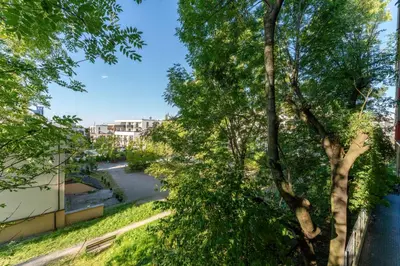 a view through the trees of a street at Łagiewniki Homely Apartment by BookingHost in Kraków