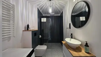 a living room with a couch and a tv at Anthracite Apartment on Felicjanek Street by CityBeat in Kraków
