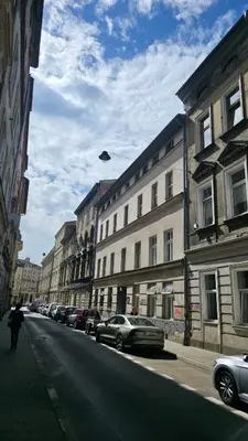 a person flying a kite on a city street at Anthracite Apartment on Felicjanek Street by CityBeat in Kraków