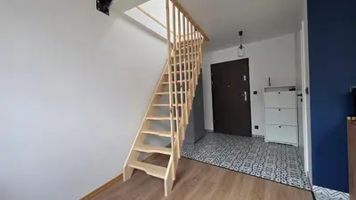 a kitchen with a table and a blue wall at Anthracite Apartment on Felicjanek Street by CityBeat in Kraków